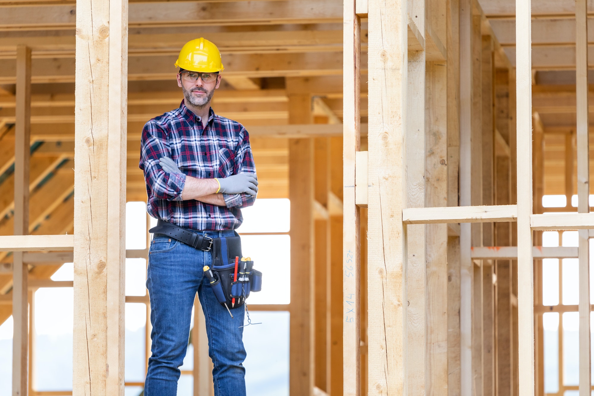 builder worker on construction site of frame house